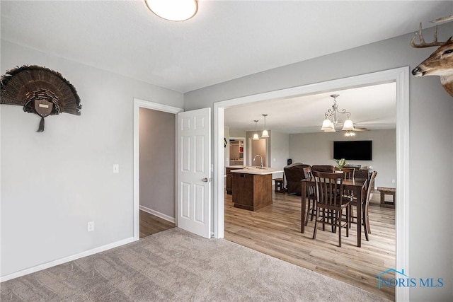 116 Wirth Ln, Sherwood, OH 43556 - dining space with baseboards, light carpet, a chandelier, and light wood-type flooring