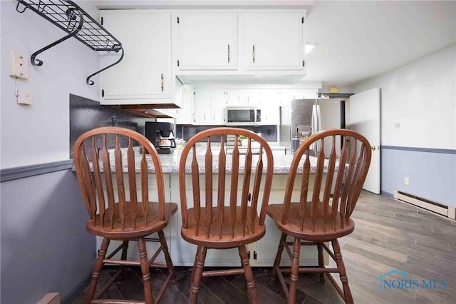 206 N Park Dr, Mccomb, OH 45858 - dining space with a baseboard radiator, wood finished floors, and baseboards