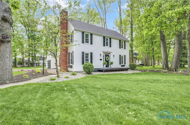 524 Sutton Pl, Findlay, OH 45840 - colonial house featuring a chimney, a front yard, and a wooden deck
