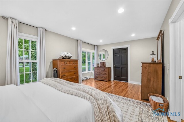 524 Sutton Pl, Findlay, OH 45840 - bedroom with a baseboard heating unit, multiple windows, wood finished floors, recessed lighting, and baseboards