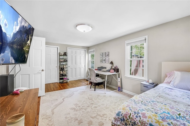 524 Sutton Pl, Findlay, OH 45840 - bedroom featuring an office area, multiple closets, wood finished floors, and baseboards