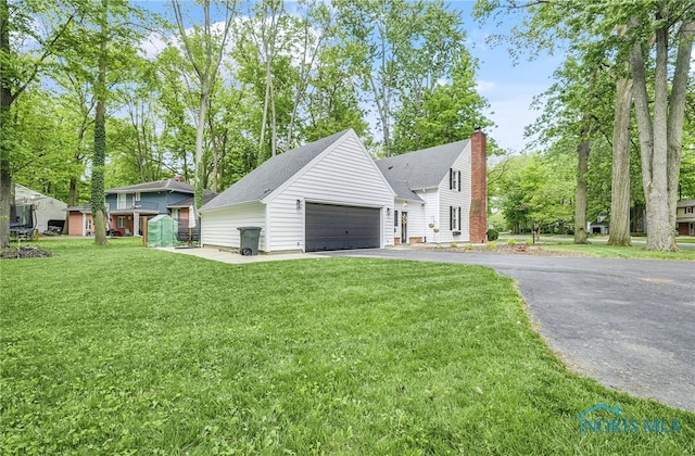 524 Sutton Pl, Findlay, OH 45840 - view of front of home with a detached garage, a chimney, a front lawn, and a shingled roof