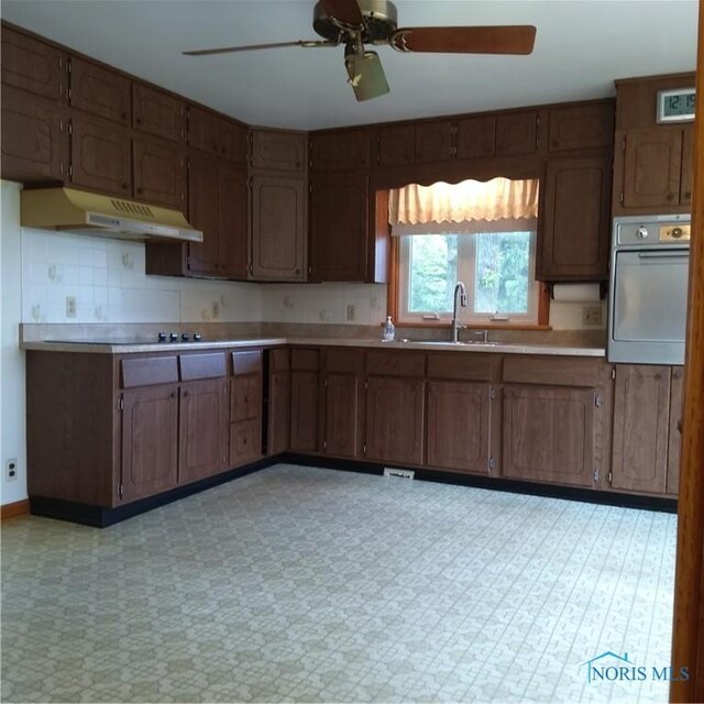 15979 Hill Rd, Defiance, OH 43512 - kitchen with wall oven, a sink, under cabinet range hood, ceiling fan, and light countertops
