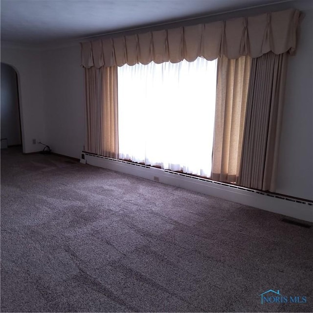 15979 Hill Rd, Defiance, OH 43512 - unfurnished room with baseboard heating, arched walkways, and carpet floors
