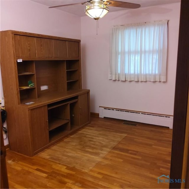 15979 Hill Rd, Defiance, OH 43512 - unfurnished living room featuring ceiling fan, a baseboard heating unit, and light wood finished floors