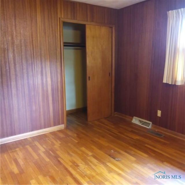 15979 Hill Rd, Defiance, OH 43512 - unfurnished bedroom featuring a closet, wood finished floors, and wooden walls