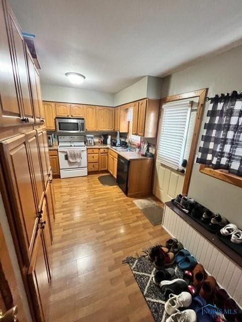663 W Summit St, Fostoria, OH 44830 - kitchen featuring white electric range, stainless steel microwave, dishwasher, light wood finished floors, and light countertops