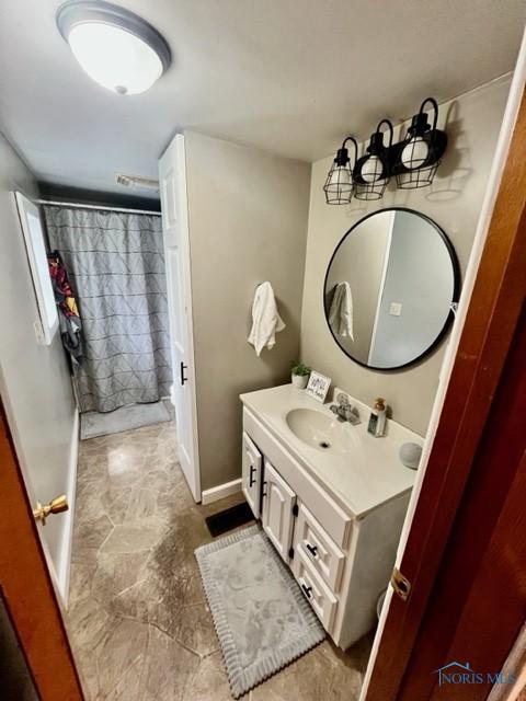 663 W Summit St, Fostoria, OH 44830 - bathroom with vanity, baseboards, and curtained shower