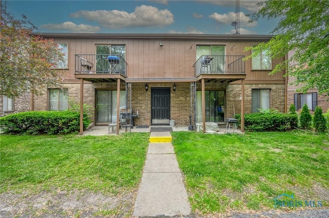 1701 Brownstone Blvd, Toledo, OH 43614 - view of front of home featuring a balcony, a front lawn, and brick siding