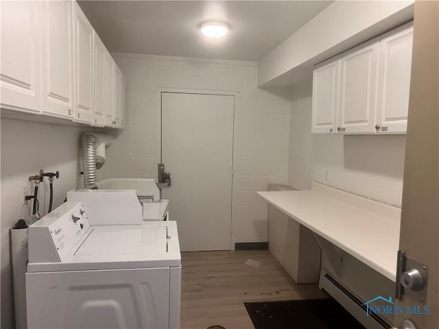 2134 Tedrow Rd, Toledo, OH 43614 - washroom featuring cabinet space, light wood-style floors, separate washer and dryer, a baseboard radiator, and concrete block wall