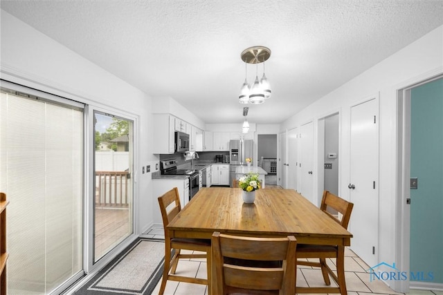 117 Freedom Ln, Waterville, OH 43566 - dining room with light tile patterned floors, a chandelier, and a textured ceiling
