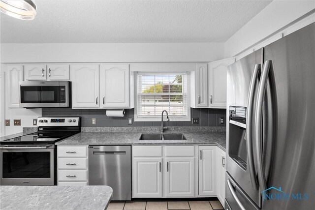 117 Freedom Ln, Waterville, OH 43566 - kitchen featuring appliances with stainless steel finishes, a sink, a textured ceiling, white cabinetry, and light tile patterned floors