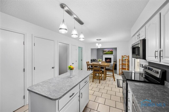 117 Freedom Ln, Waterville, OH 43566 - kitchen featuring stainless steel appliances, a textured ceiling, white cabinets, light tile patterned flooring, and decorative light fixtures