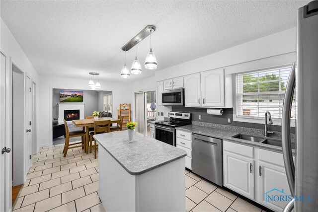 117 Freedom Ln, Waterville, OH 43566 - kitchen with appliances with stainless steel finishes, a sink, a kitchen island, white cabinets, and decorative light fixtures