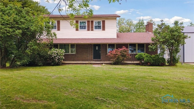 13914 Devils Hole Rd, Bowling Green, OH 43402 - traditional home featuring a chimney, a front yard, and brick siding