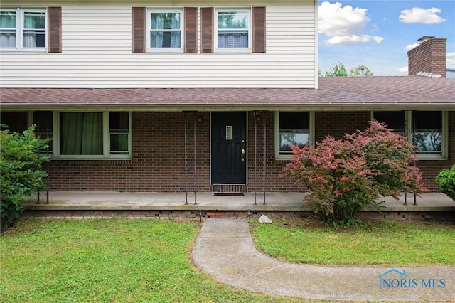 13914 Devils Hole Rd, Bowling Green, OH 43402 - view of front of home with brick siding, a front lawn, a porch, a chimney, and a shingled roof
