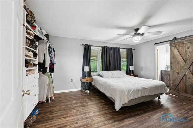 13914 Devils Hole Rd, Bowling Green, OH 43402 - bedroom featuring a barn door, baseboards, wood finished floors, and a ceiling fan