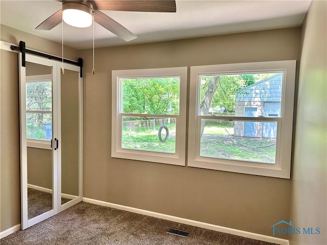 3530 Helene Ct, Toledo, OH 43623 - spare room with carpet, baseboards, a ceiling fan, and a barn door