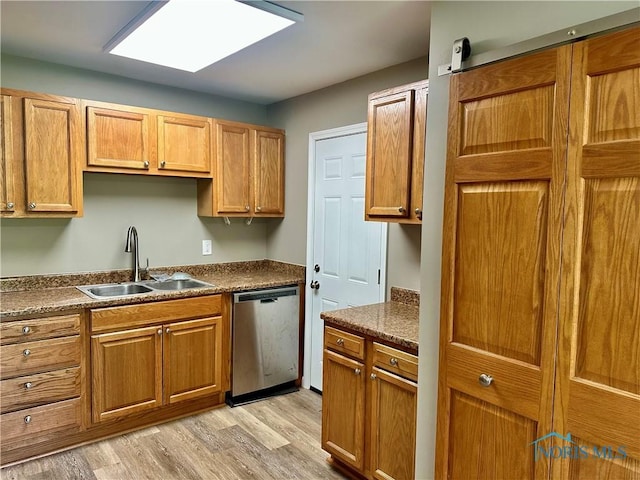 3530 Helene Ct, Toledo, OH 43623 - kitchen with stainless steel dishwasher, a sink, light wood-type flooring, dark countertops, and brown cabinets
