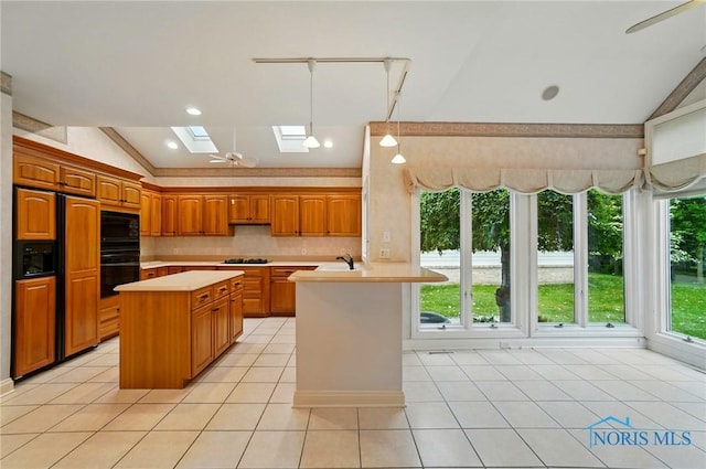 3236 Deep Water Ln, Maumee, OH 43537 - kitchen with vaulted ceiling, a skylight, light countertops, black appliances, and backsplash