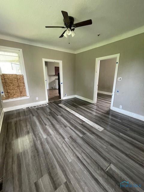821 Vinton St, Toledo, OH 43609 - unfurnished living room with dark wood-style floors, baseboards, and ceiling fan
