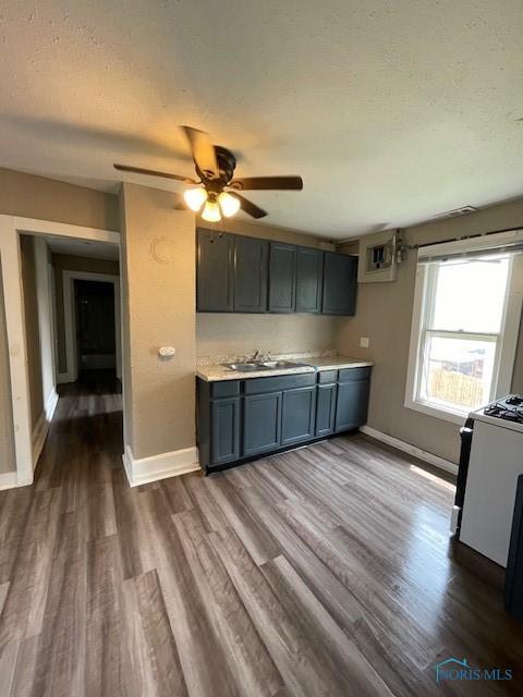 821 Vinton St, Toledo, OH 43609 - kitchen featuring white stove, dark wood-style flooring, baseboards, a textured ceiling, and ceiling fan
