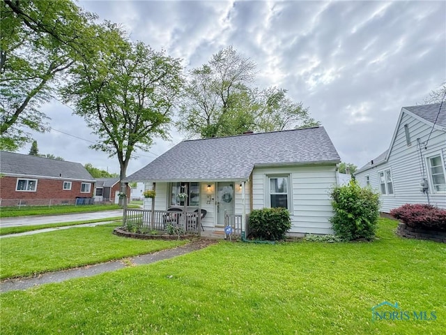 4635 Vermaas Ave, Toledo, OH 43612 - bungalow-style home featuring covered porch, a front lawn, and roof with shingles