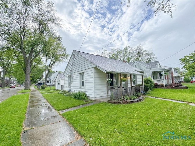 4635 Vermaas Ave, Toledo, OH 43612 - view of side of property featuring a porch, a lawn, and a shingled roof