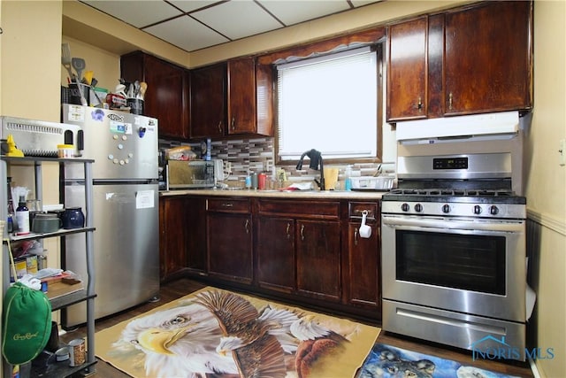2544 110th St, Toledo, OH 43611 - kitchen featuring appliances with stainless steel finishes, under cabinet range hood, a sink, backsplash, and light countertops