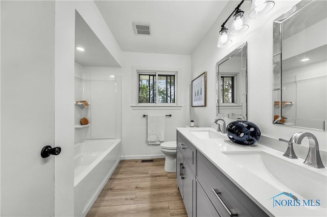 3407 Waterville Swanton Rd, Swanton, OH 43558 - bathroom featuring toilet, wood finished floors, double vanity, baseboards, and shower / bathtub combination
