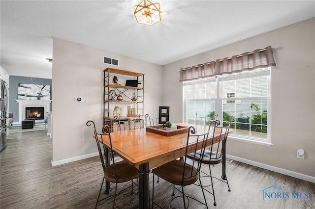 819 Wood Sorrel Ln, Perrysburg, OH 43551 - dining area with baseboards, wood finished floors, and a lit fireplace