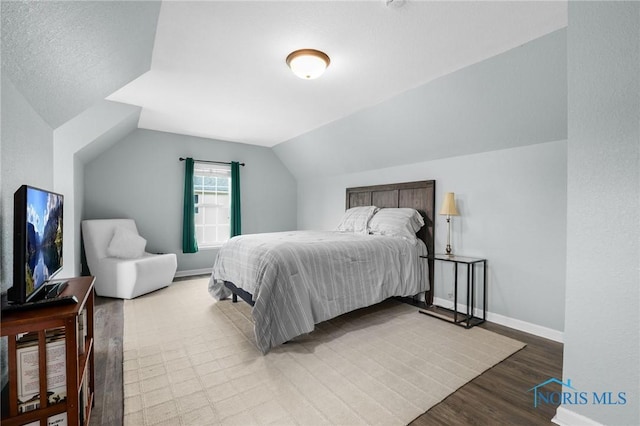 819 Wood Sorrel Ln, Perrysburg, OH 43551 - bedroom with wood finished floors, vaulted ceiling, and baseboards