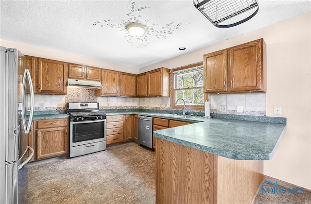 7195 Twin Lakes Rd, Perrysburg, OH 43551 - kitchen featuring stainless steel appliances, under cabinet range hood, a peninsula, a sink, and brown cabinets