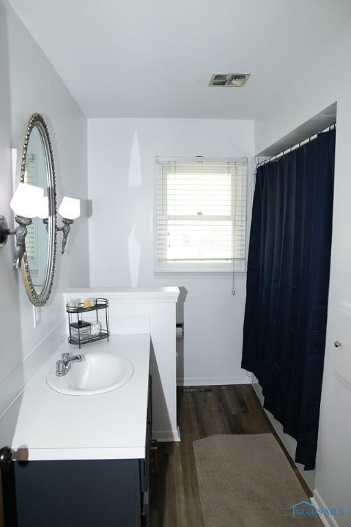615 Hillcrest Ave, Findlay, OH 45840 - bathroom featuring vanity, wood finished floors, a shower with shower curtain, and baseboards