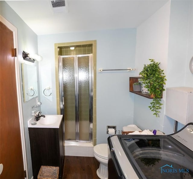 615 Hillcrest Ave, Findlay, OH 45840 - full bath featuring washer / clothes dryer, vanity, a shower stall, toilet, and wood finished floors