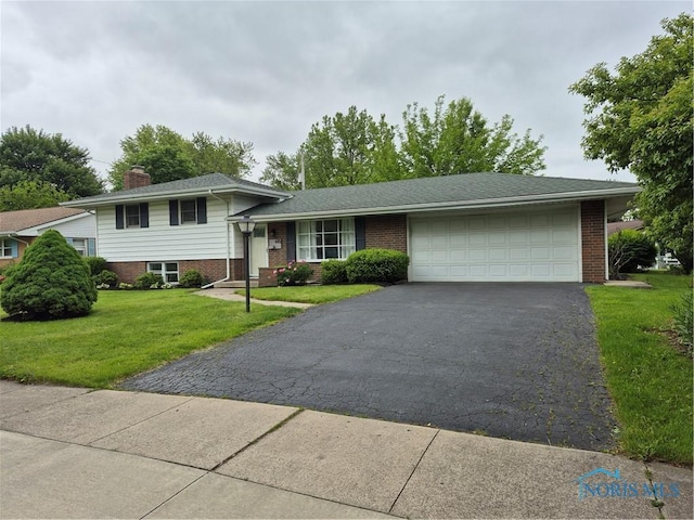 615 Hillcrest Ave, Findlay, OH 45840 - tri-level home featuring a garage, brick siding, and asphalt driveway