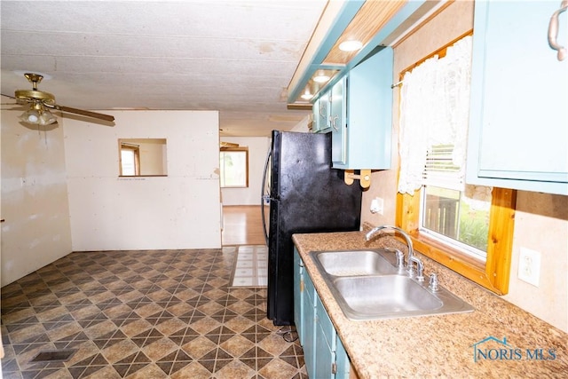 28916 Blanchard Rd, Defiance, OH 43512 - kitchen with a sink, a ceiling fan, light countertops, blue cabinetry, and freestanding refrigerator