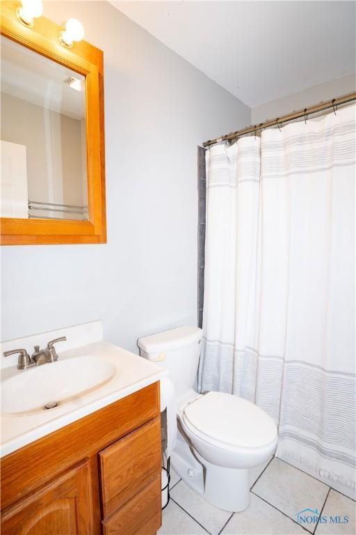 1618 S Clinton St, Defiance, OH 43512 - bathroom with vanity, tile patterned flooring, toilet, and a shower with curtain