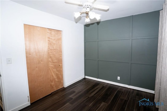1618 S Clinton St, Defiance, OH 43512 - unfurnished bedroom with dark wood finished floors, baseboards, a closet, a ceiling fan, and a decorative wall