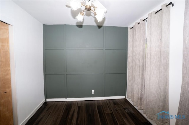 1618 S Clinton St, Defiance, OH 43512 - empty room featuring dark wood-type flooring, a decorative wall, and baseboards