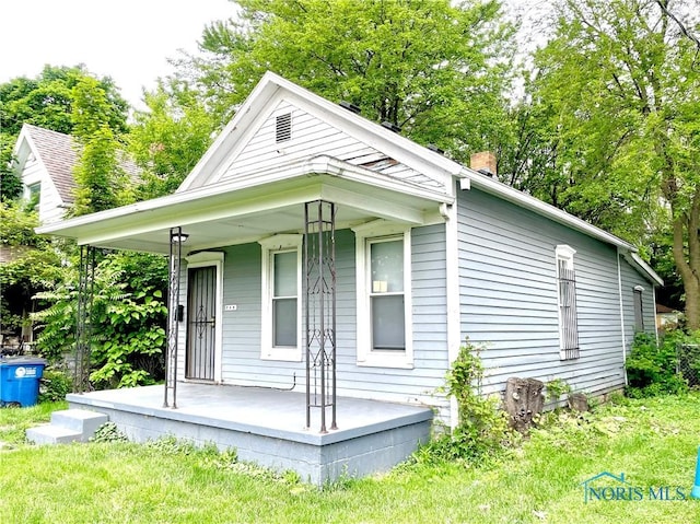 219 N Everett St, Toledo, OH 43608 - view of front of house with a porch and a chimney