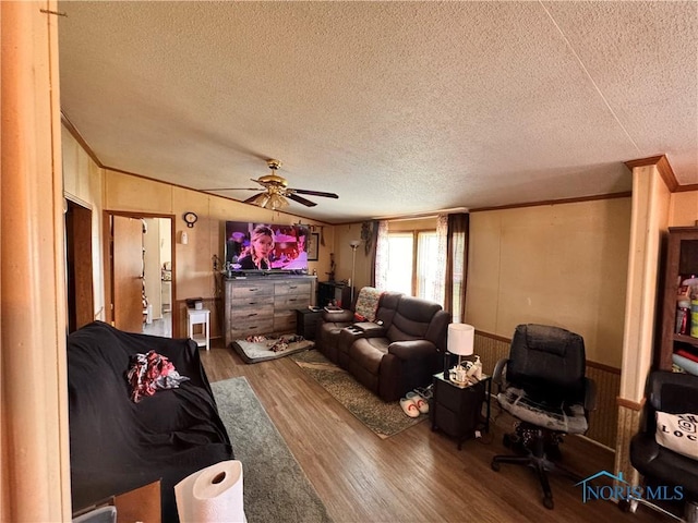 15807 State Route 49, Edon, OH 43518 - living room with crown molding, wood finished floors, a textured ceiling, a ceiling fan, and wood walls