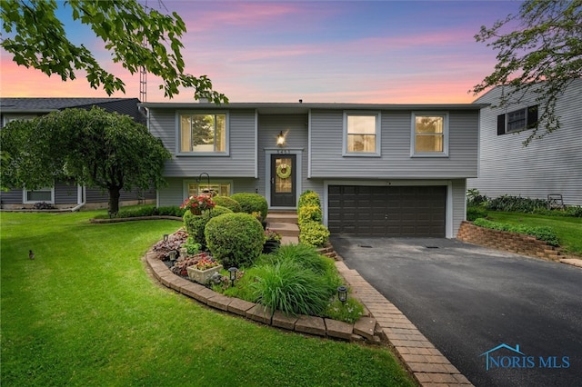 5453 Brook Point Rd, Toledo, OH 43611 - raised ranch featuring asphalt driveway, an attached garage, and a front lawn