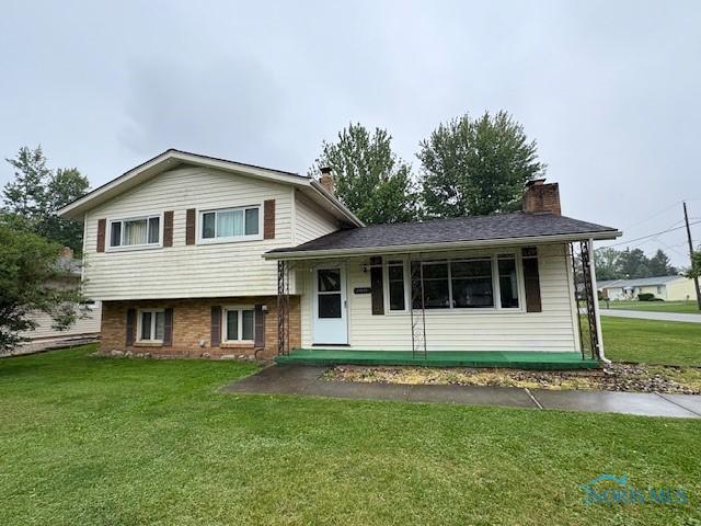 23695 E Second St, Grand Rapids, OH 43522 - tri-level home featuring a front lawn, a chimney, and brick siding