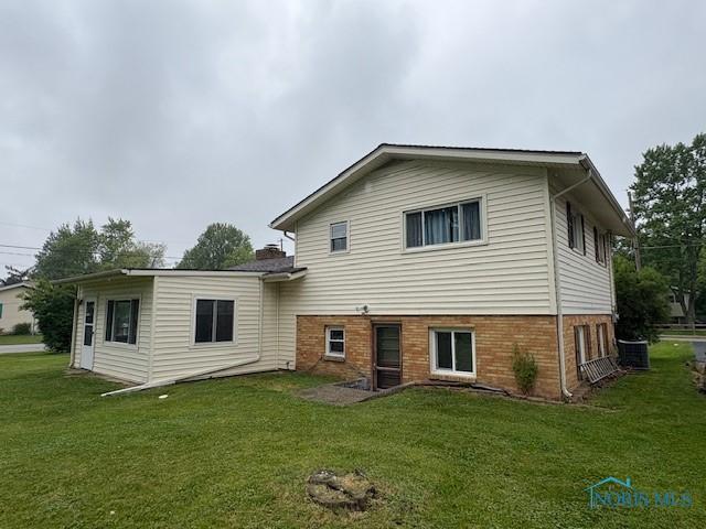 23695 E Second St, Grand Rapids, OH 43522 - rear view of house featuring a yard, central AC, and brick siding