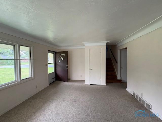 23695 E Second St, Grand Rapids, OH 43522 - unfurnished living room with stairs, light carpet, and baseboards