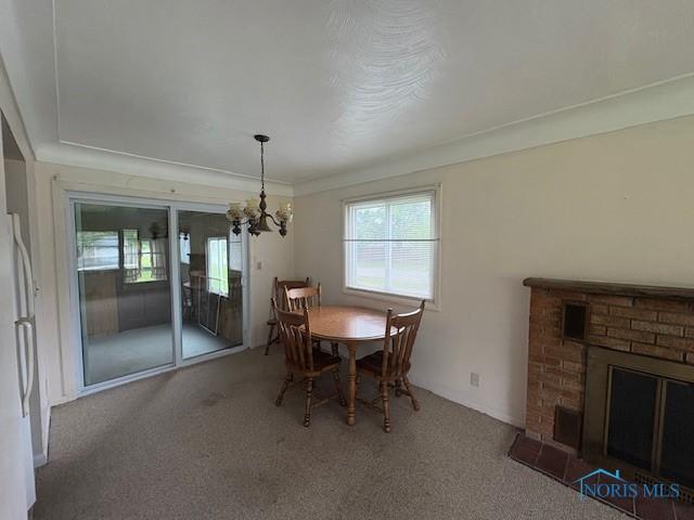 23695 E Second St, Grand Rapids, OH 43522 - carpeted dining space featuring a chandelier and a fireplace
