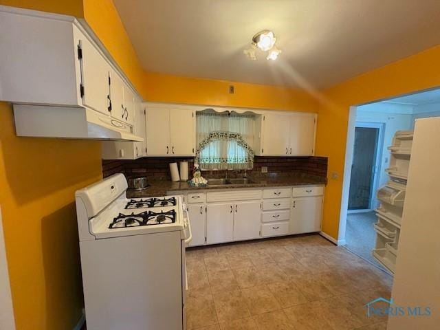 23695 E Second St, Grand Rapids, OH 43522 - kitchen with white range with gas stovetop, tasteful backsplash, dark countertops, white cabinetry, and under cabinet range hood