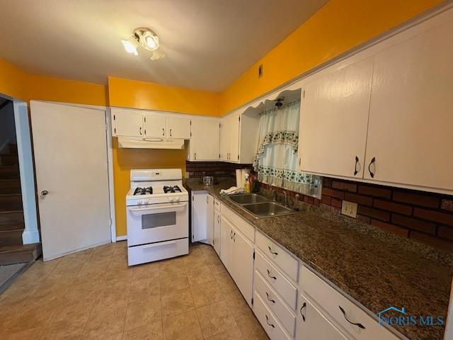 23695 E Second St, Grand Rapids, OH 43522 - kitchen featuring white gas range oven, a sink, under cabinet range hood, white cabinetry, and tasteful backsplash