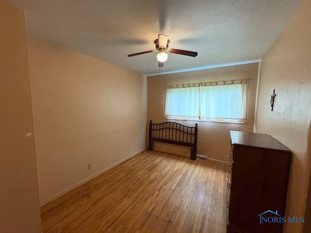 23695 E Second St, Grand Rapids, OH 43522 - empty room with a ceiling fan, light wood finished floors, and baseboards